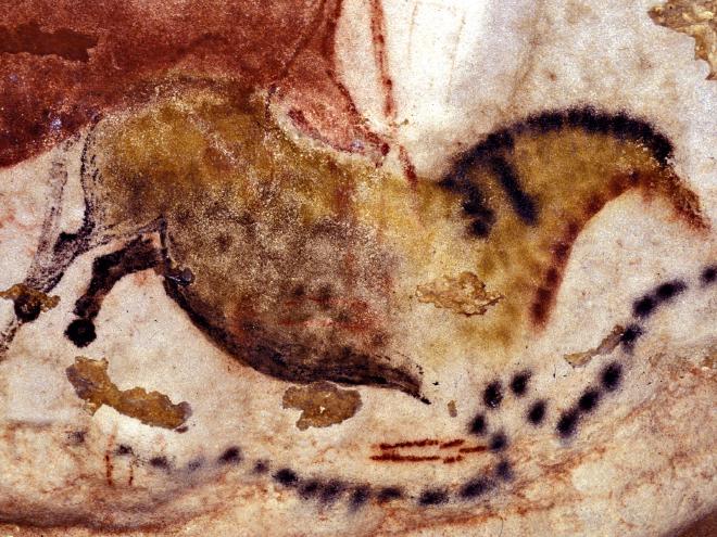 A cave painting of a horse in Lascaux, with a curving line of dots painted below.