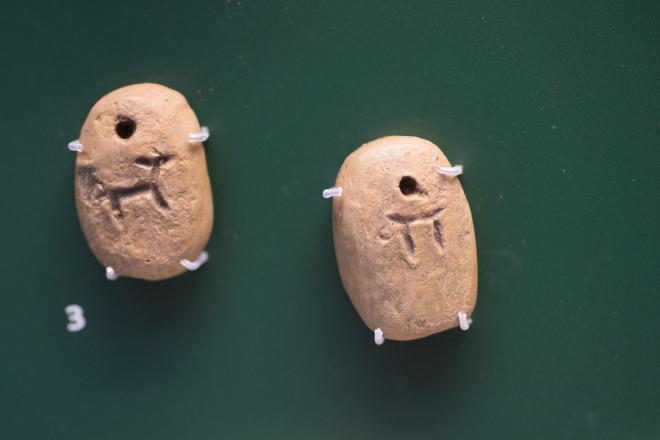 Pictographic clay tags depicting a goat and a numeral.